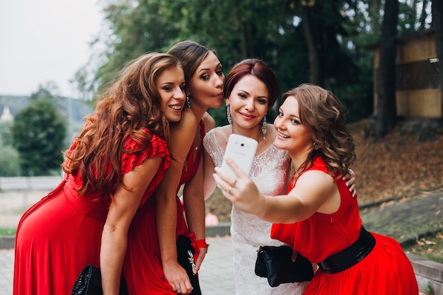 Portrait of three beautiful bridesmaids in red dress