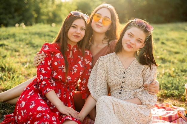 portrait of three beautiful young women in summer on a picnic