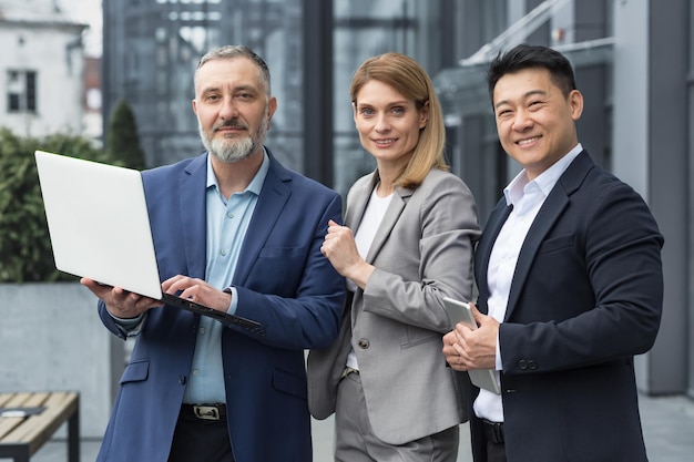 Portrait of three diverse business colleagues business group outside office building asian man and