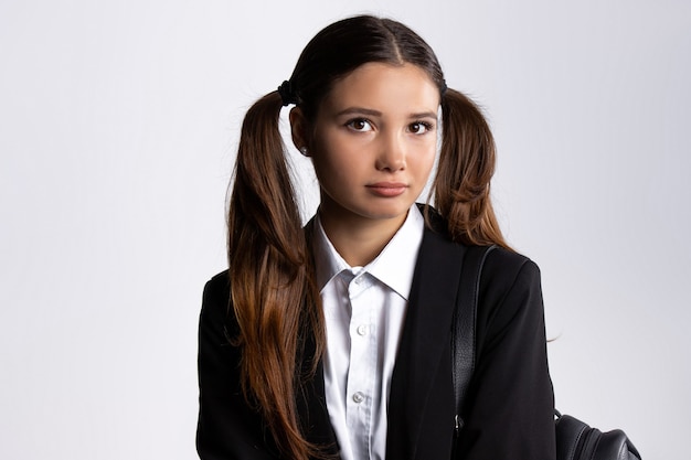 Portrait of a tired female in a uniform on a white wall with side space