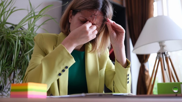 Portrait of tired office manager sitting at workplace in office stressful and exhausted