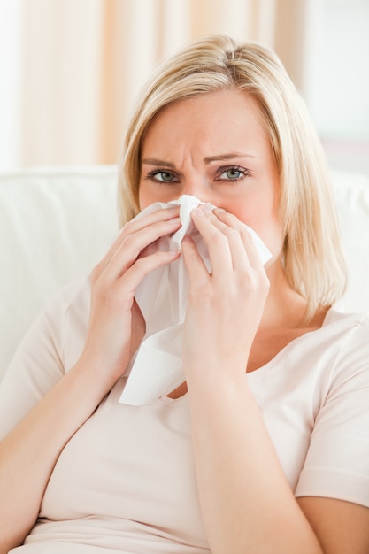 Portrait of a tired woman blowing her nose