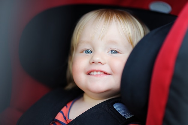 Portrait of toddler boy sitting in car seat