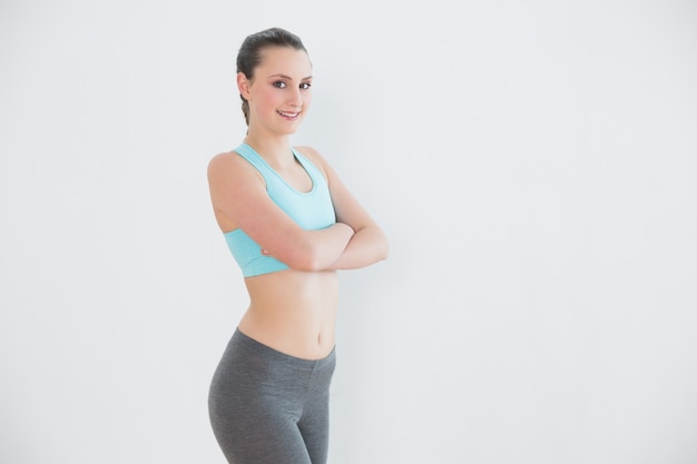 Portrait of toned woman against wall