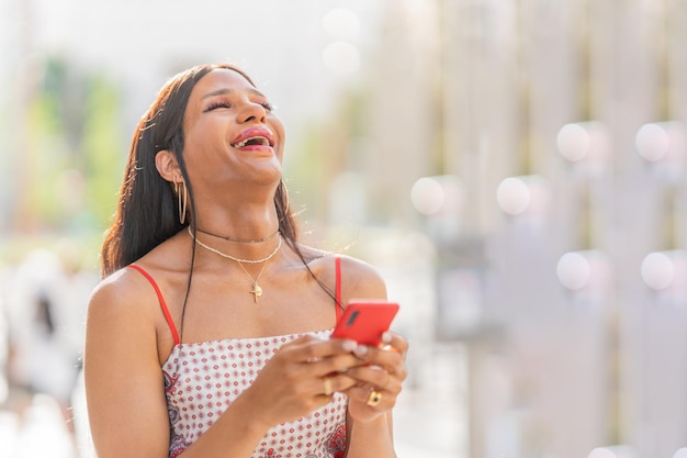 Portrait of a trans woman laughing and using the mobile