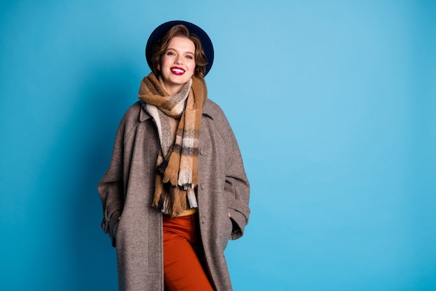 Photo portrait of traveler lady toothy smiling good mood sunny day weather wear stylish casual season grey coat yellow pullover orange pants hat .