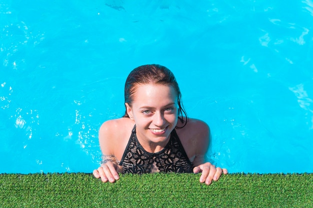 Portrait of trendy fit girl in swim wear with open eyes enjoying rest sunlight over blue background travel tourism journey trip tour concept