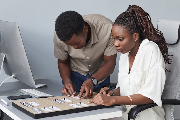 Photo portrait of two african-american business people planning to do chart while working together in office