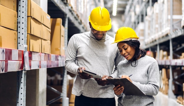 Portrait two african american engineer team shipping order detail on tablet check goods and supplies on shelves with goods inventory in factory warehouselogistic industry and business export