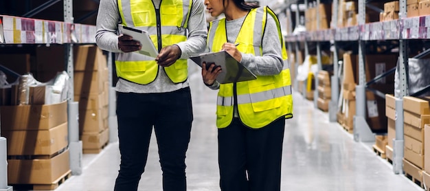 Portrait two african american engineer team shipping order detail on tablet check goods and supplies on shelves with goods inventory in factory warehouselogistic industry and business export