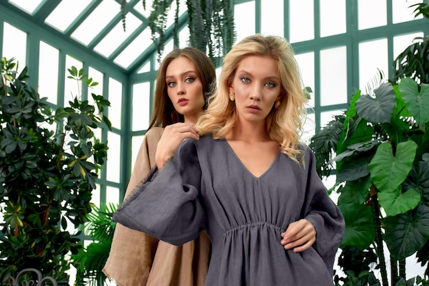 Portrait of two beautiful caucasian girls models in the greenhouse