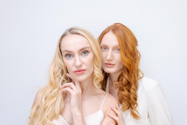 Portrait two cheerful blonde and redhead women in summer wear smiling posing