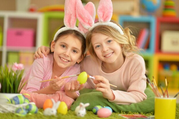 Portrait of two cute girls painted Easter eggs