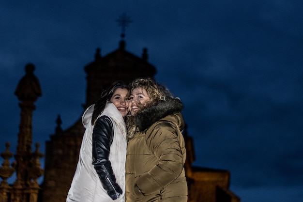 Portrait of two female friends making kissing gestures Two female friends making kissing gestures outdoors