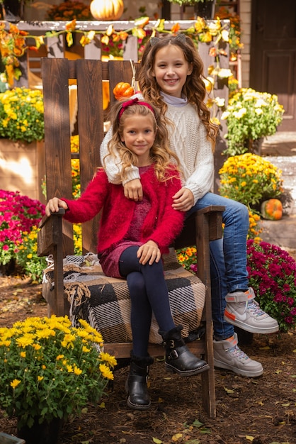 portrait of two girls sisters in autumn near the house