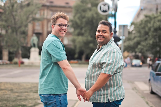 portrait of two men holding hands in the street