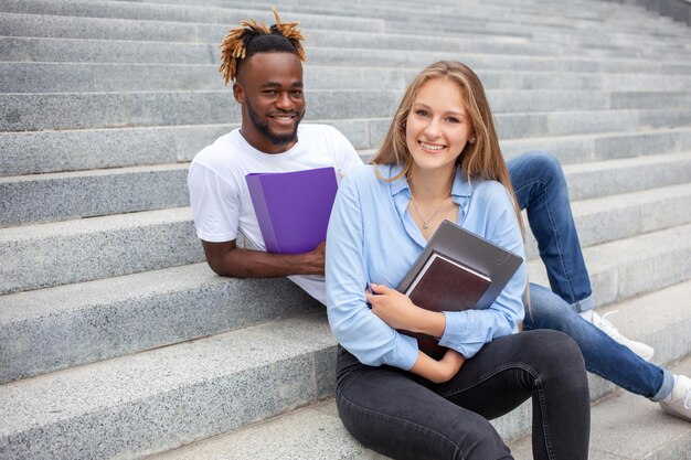 Portrait of two mixed race friends students with happy faces