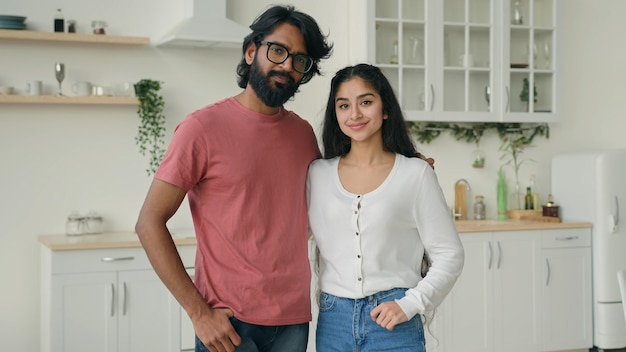 Portrait of two people multiracial couple in love posing in domestic white kitchen arabian hispanic