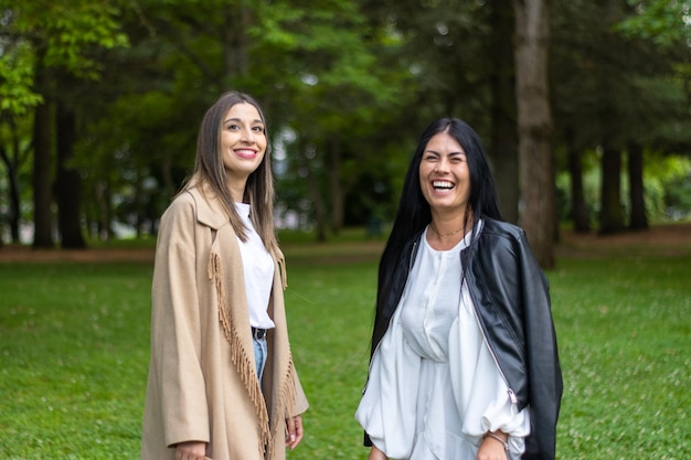 Portrait of two smiling women looking at camera in the park