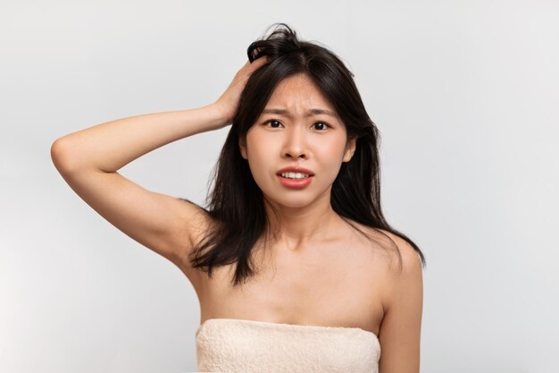 Portrait of unhappy asian lady grabbing her head