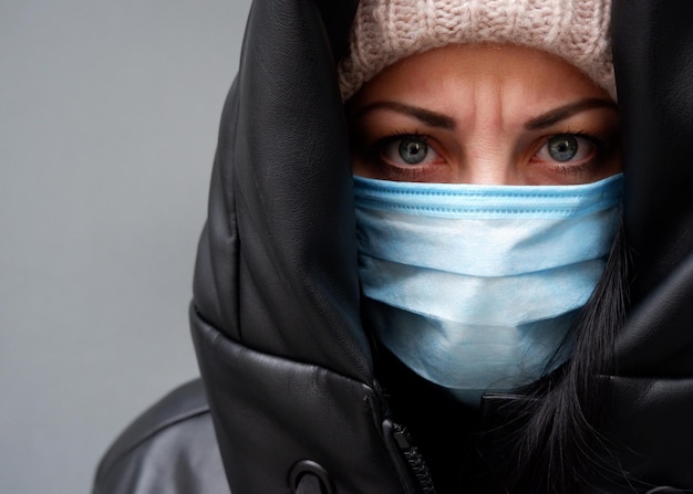 Portrait of an unhappy woman in a mask to fight the virus or pollution