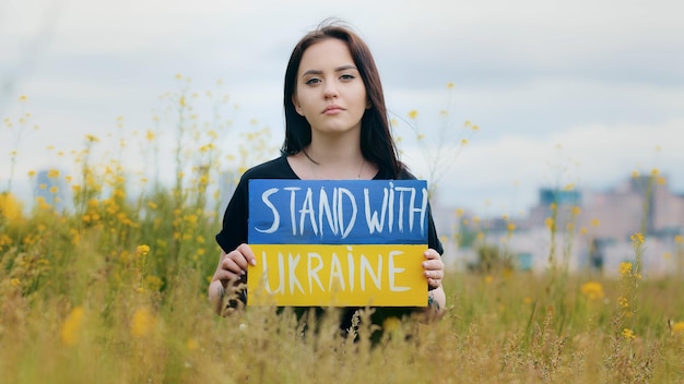 Portrait of upset girl woman patriot holding cardboard inscription political slogan stand with