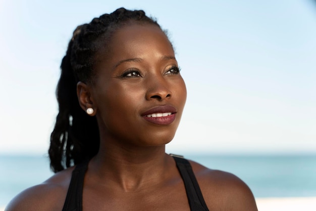 Portrait view of the healthy african american woman preparing doing exercises on the beach