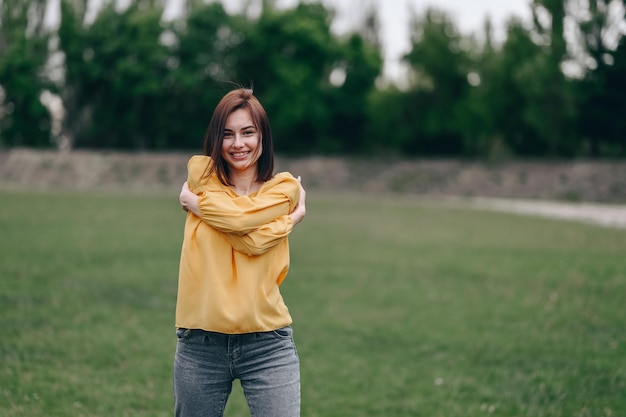 Portrait of a waistlength girl with a caret who rejoices and hugs herself while looking at camera