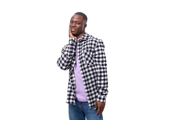 Portrait of a wellgroomed darkskinned man in a plaid shirt and jeans isolated on white space