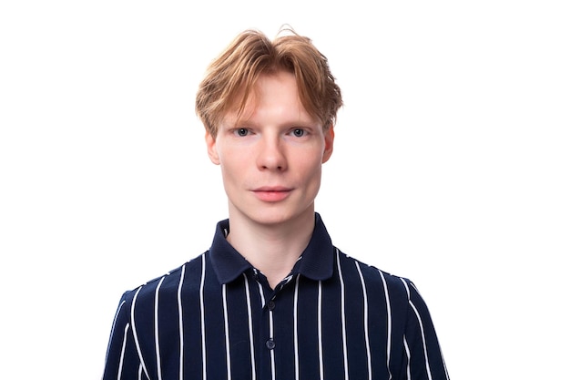 Portrait of a wellgroomed young blond guy in a striped polo shirt on a white background