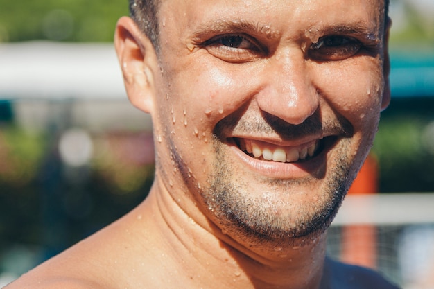 Portrait of a wet man. Drops trickle down my face. Happy man after hard physical work.  strength exercises, weight loss, tan, swimming