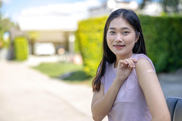 Portrait of woman after getting Covid-19 vaccine or Flu influenza vaccine at field hospital. Corona virus treatment side effect, Vaccination, immunization, disease prevention concept.