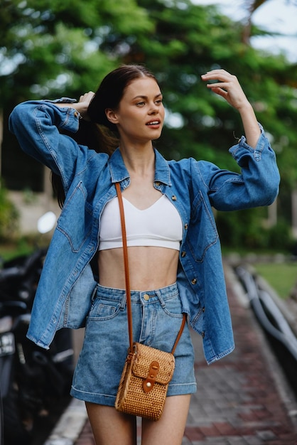 Portrait of woman brunette smile with teeth running down the street against backdrop palm trees in the tropics summer vacations and outdoor recreation the carefree lifestyle of a freelance student