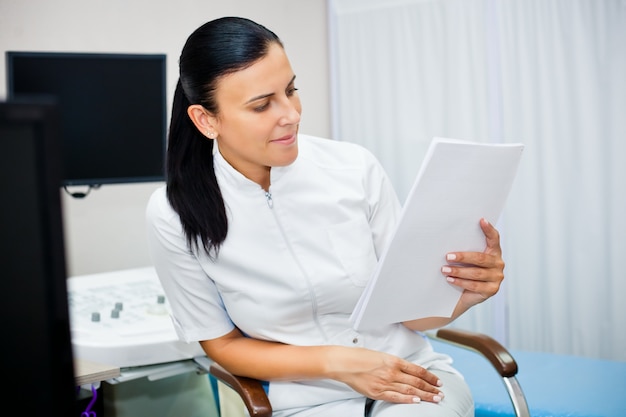 Portrait of a woman doctor with a medical history in her hands