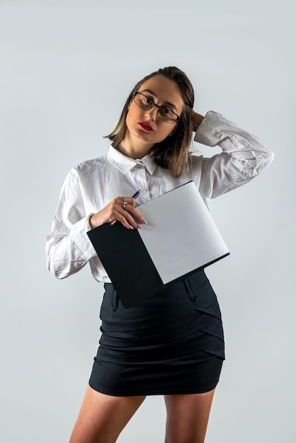 Portrait of woman in formal wear holding clipboard and smiling at camera isolated background