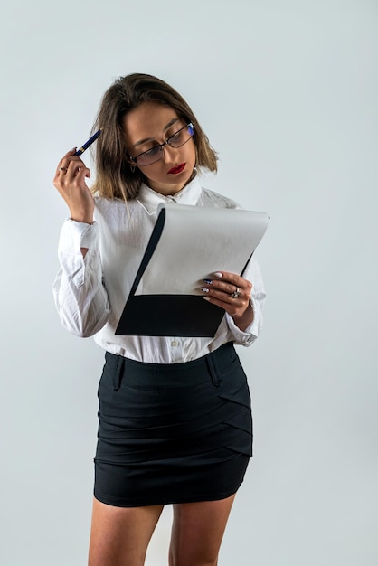 Portrait of woman in formal wear holding clipboard and smiling at camera isolated background