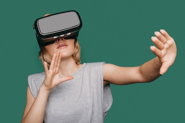 Portrait of woman getting vr experience being in virtual reality woman touching air during vr experi...