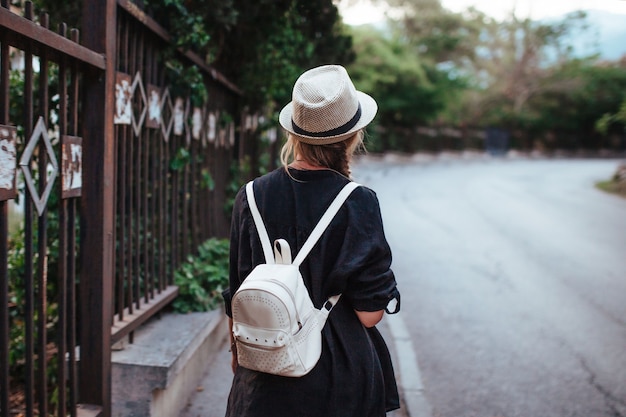 Portrait of a woman in a hat with a backpack on her back