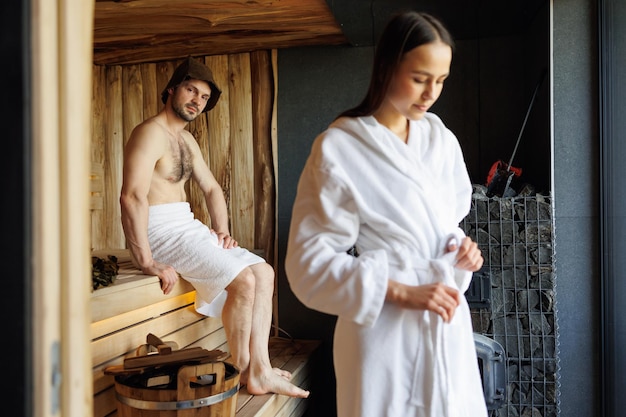 Portrait of a woman and her man in the background in the sauna