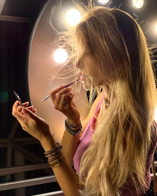 Photo portrait of woman holding illuminated lighting equipment