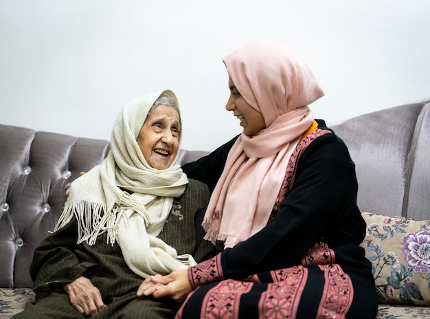 Portrait of woman hugging daughter with positive face. Third age, Home care concept. High quality photo