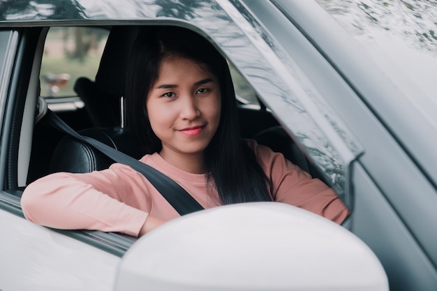 Portrait of woman  is smiling while driving a car.