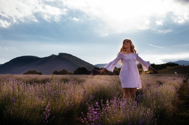 Portrait of woman is standing among the plantations of lavender