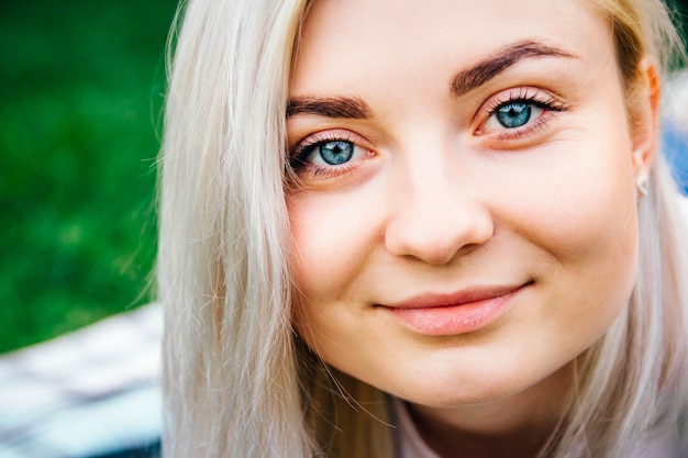 Portrait woman looking and smiling in frame on green grass background