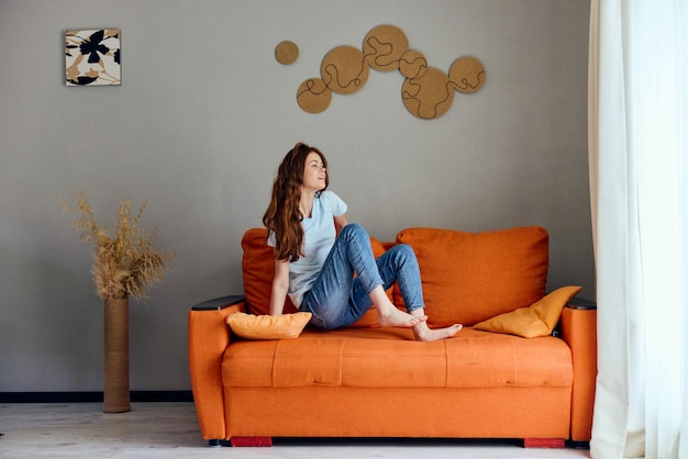 Portrait of a woman on the orange couch in the rest room posing unaltered