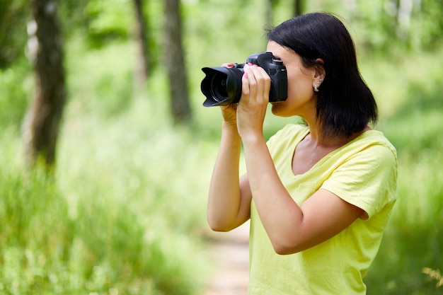 Portrait of a woman photographer covering her face with the camera