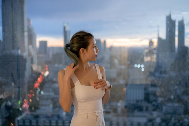 Portrait woman posing on balcony with city view