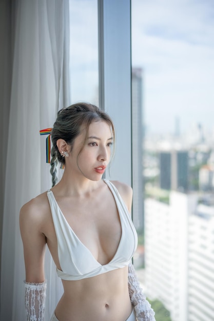 Portrait woman posing in underwear on her balcony with city view