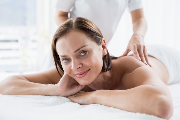 Portrait of woman receiving back massage from masseur