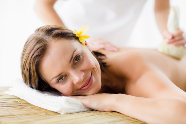 Portrait of woman receiving herbal compress massage